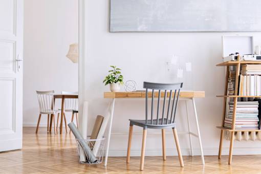 A room with a table, chairs and a plant.