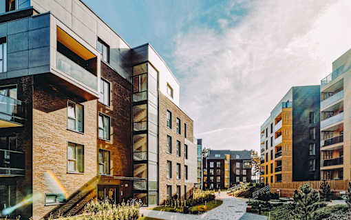 A modern apartment complex with a mix of brick and glass buildings.