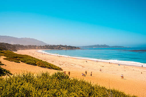 A beach with people enjoying the sun and sand.