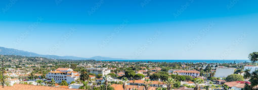 A coastal cityscape with buildings and a clear blue sky.