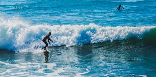 A surfer rides a wave in the ocean.