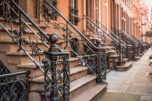A row of brown steps with black metal railings.