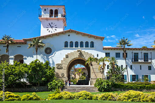 A white building with a clock tower and a large archway entrance.