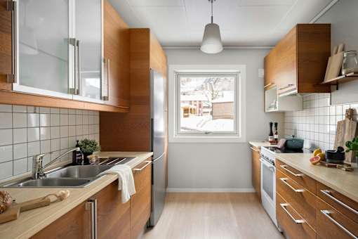 A kitchen with wooden cabinets and a stainless steel sink.
