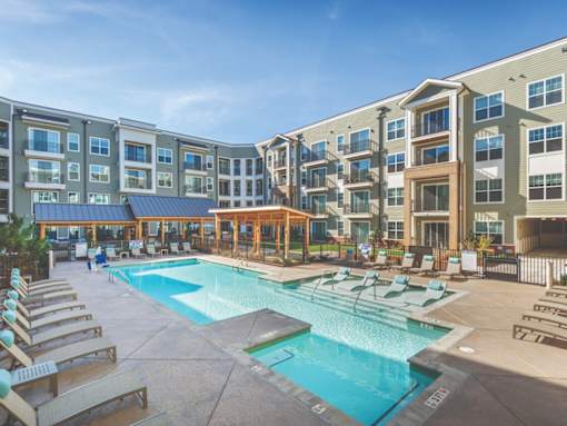 a swimming pool with chaise lounge chairs and a gazebo in front of an