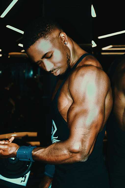 a man wearing a tank top and looking at his cell phone