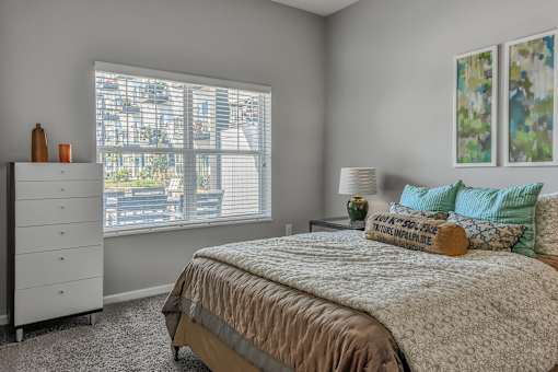 a bedroom with a bed and a large window