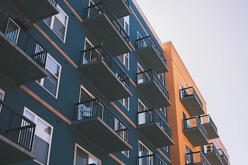 A tall building with balconies on each floor.
