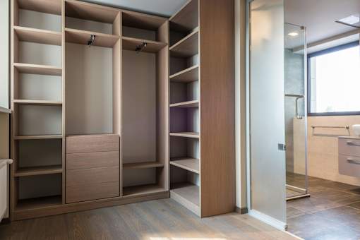 A walk-in closet with shelves and drawers.