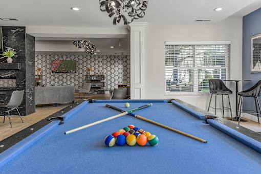 a game room with a pool table and billiard balls