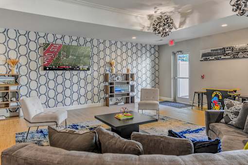 a living room with couches and chairs and a tv
