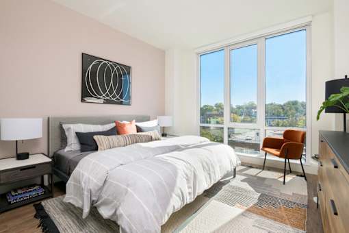 a bedroom with a bed and a large window