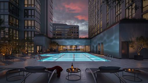 a swimming pool in between two tall buildings at sunset