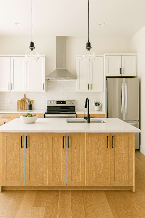 A modern kitchen with wooden cabinets and a white countertop.