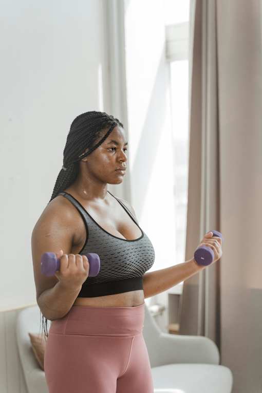 a woman exercising with dumbbells in a room
