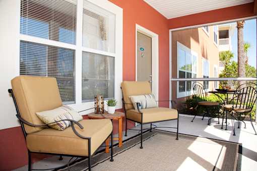 Two chairs and a table are on a patio.