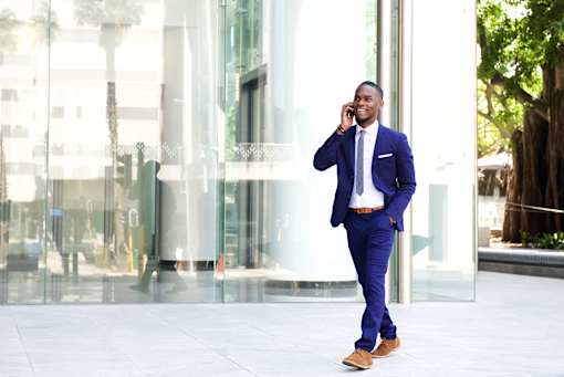 casual businessman walking and talking on phone