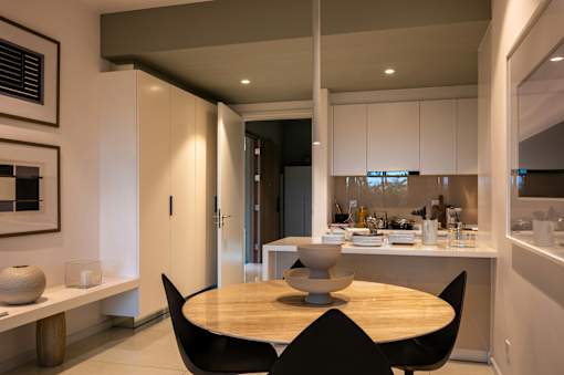 A modern kitchen with a dining table and chairs.