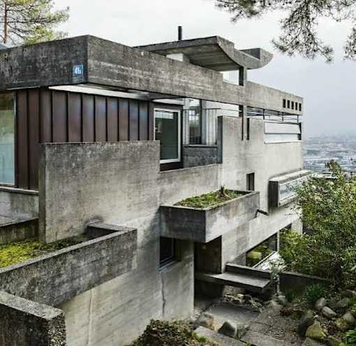 A concrete building with a balcony and a staircase leading to the second floor.