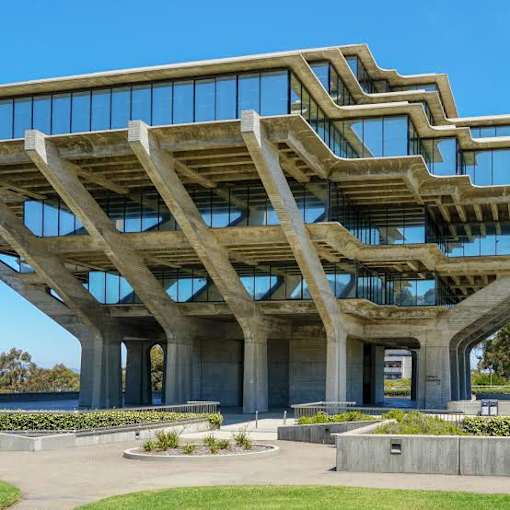 A modern building with a glass facade and a concrete structure.
