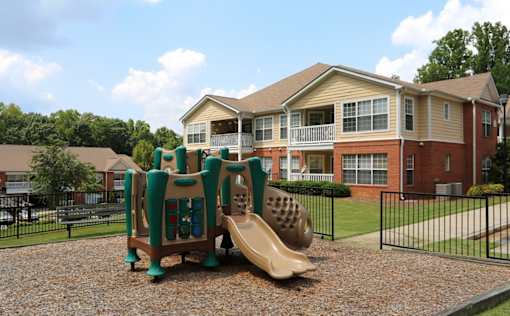 a playground with a slide in front of an apartment building