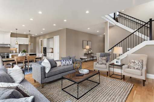 a spacious living room with a staircase leading to the second floor