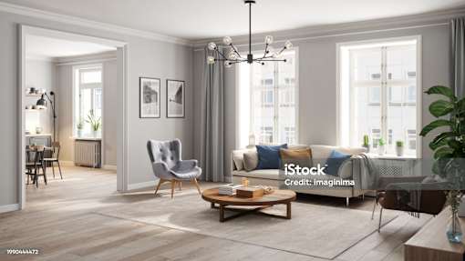 A modern living room with a grey sofa, a wooden coffee table, and a grey armchair.