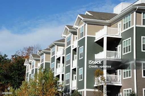 A large apartment building with multiple balconies and windows.