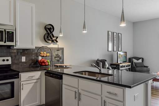 an open kitchen and living room with a large counter top