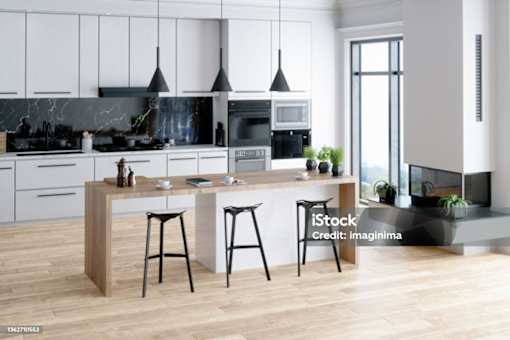 A modern kitchen with a wooden island and bar stools.