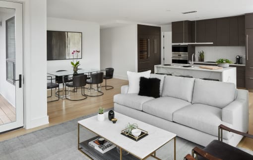 a living room with a couch and a coffee table in front of a kitchen