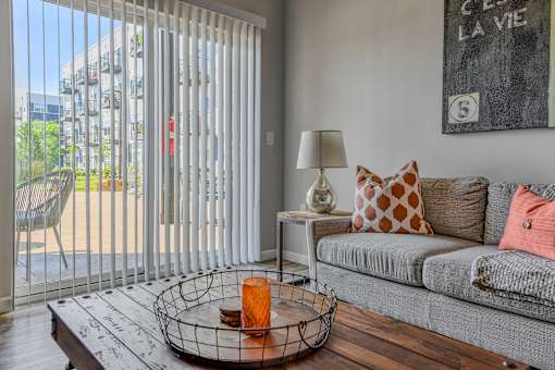 a living room with a couch and a sliding glass door to a patio