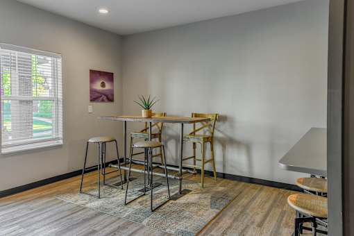 a dining area with a table and chairs and a window