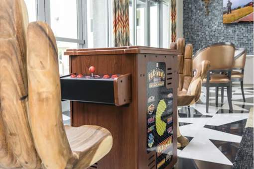 a game table in the lobby of a building with wooden chairs
