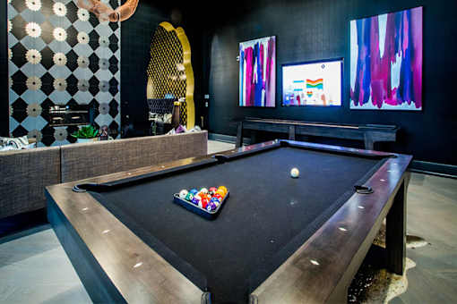 a billiards table in a game room with a tv