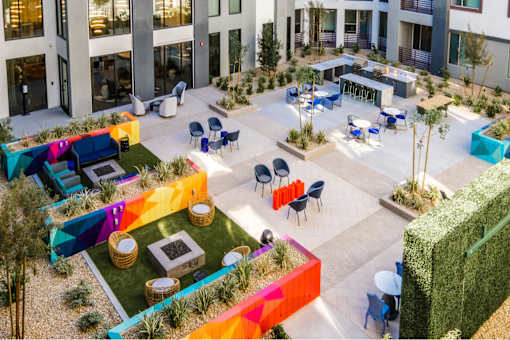 an aerial view of the courtyard of an office building with colorful tables and chairs