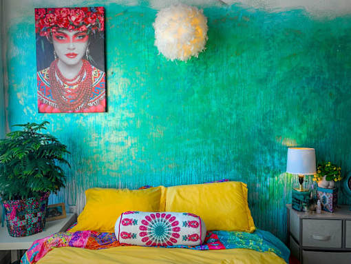 a bedroom with a yellow bed and a green wall