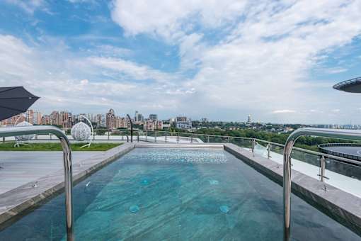 a swimming pool on the roof of a building with a city in the background
