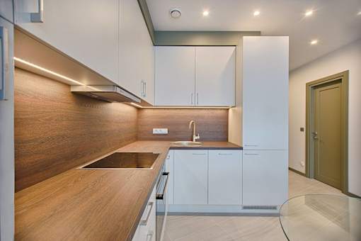 a modern kitchen with white cabinets and a wooden counter top