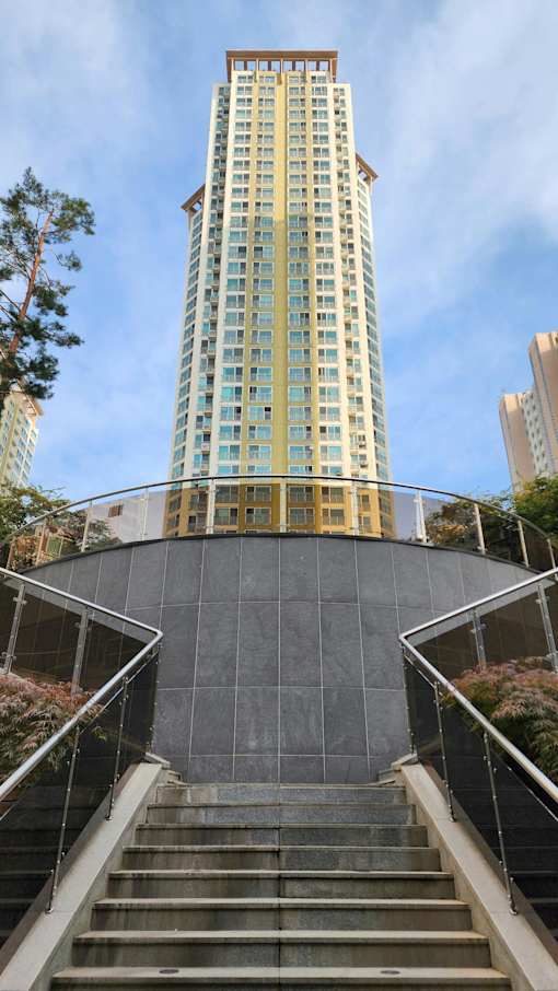 A tall building with a curved staircase in front of it.