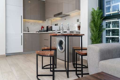 A modern kitchen with a washing machine built into the cabinetry.