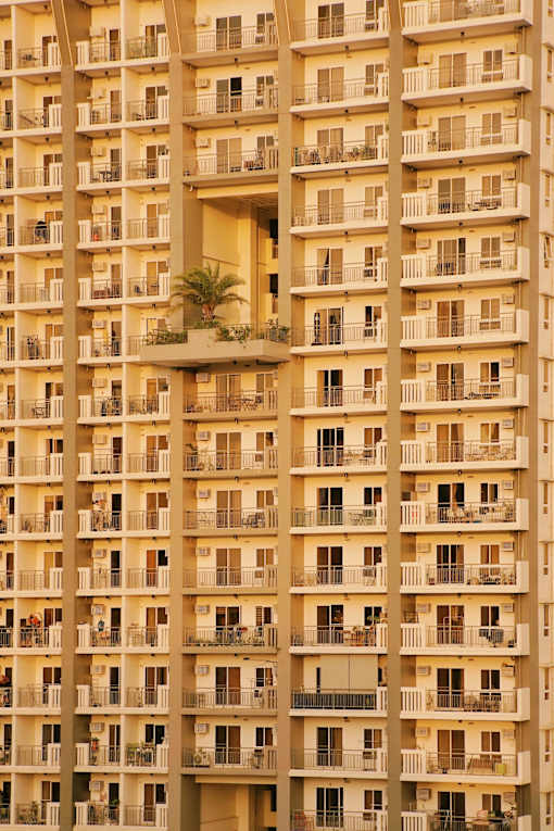 A tall apartment building with balconies and windows.