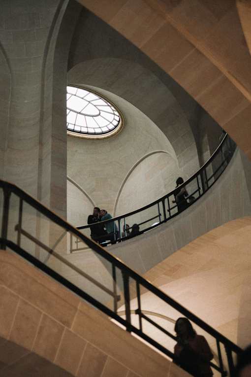 people climbing up an escalator in a building