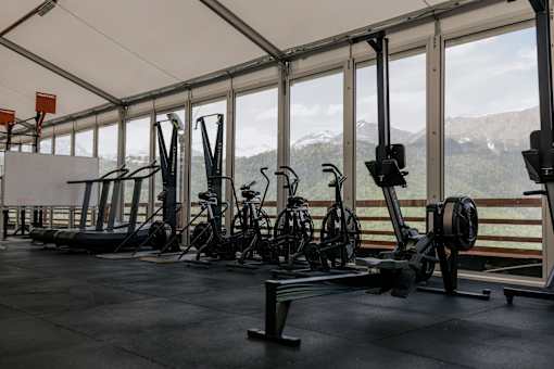 A gym with exercise equipment and a view of the mountains outside the windows.