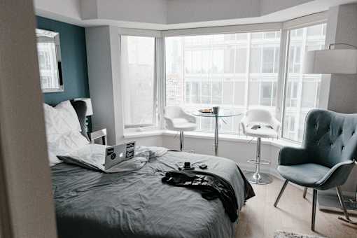 a bedroom with a bed and a laptop on top of it