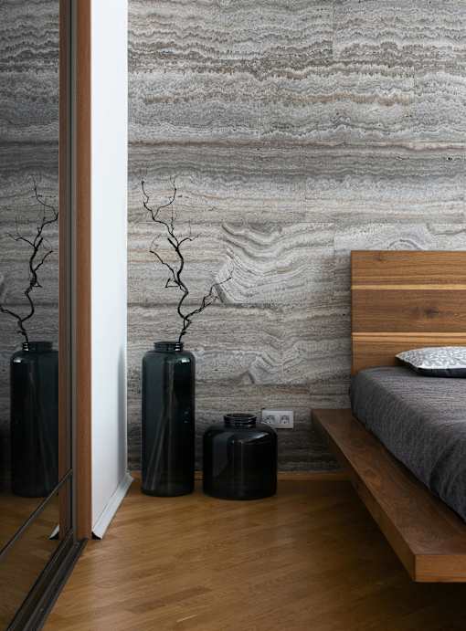 A bedroom with a bed, a nightstand, and a mirror.