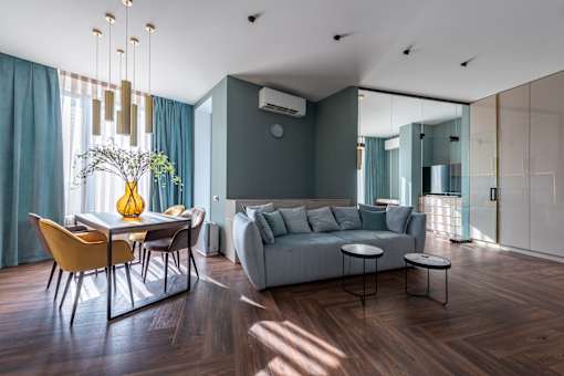 A modern living room with a dining table and a grey couch.