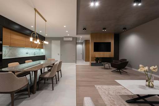 A modern dining room with a long table and chairs.