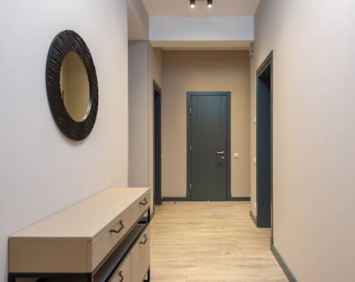 A hallway with a mirror and a door.
