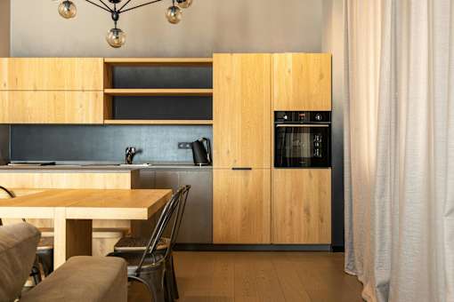 A modern kitchen with wooden cabinets and a stainless steel oven.